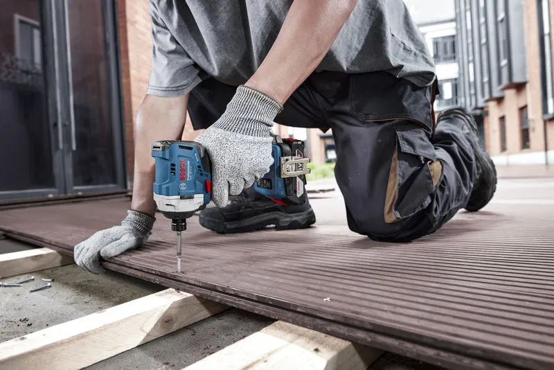 GDR 18V-215 A person wearing safety equipment uses a cordless drill to fasten decking boards.