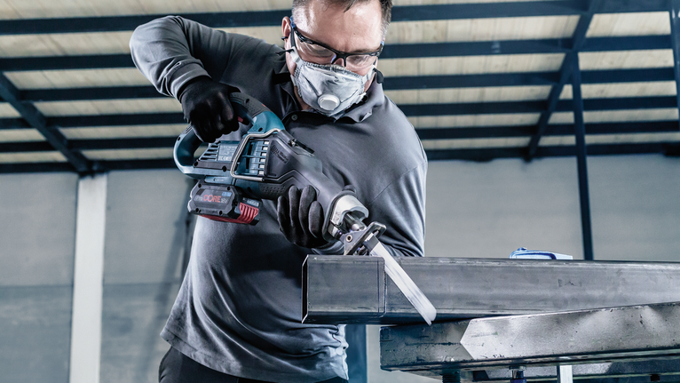 PRO Medium-Thick Metal precise S937BEF Blade, 1.1 x 25 x 150 mm, 5 pcs A person wearing safety equipment cuts a metal beam with a reciprocating saw.
