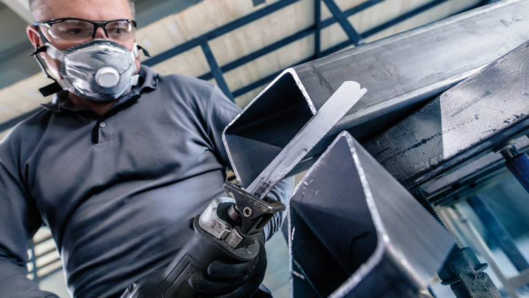 PRO Medium-Thick Metal precise S937BEF Blade, 1.1 x 25 x 150 mm, 5 pcs Person wearing safety equipment cuts a metal beam with a reciprocating saw.