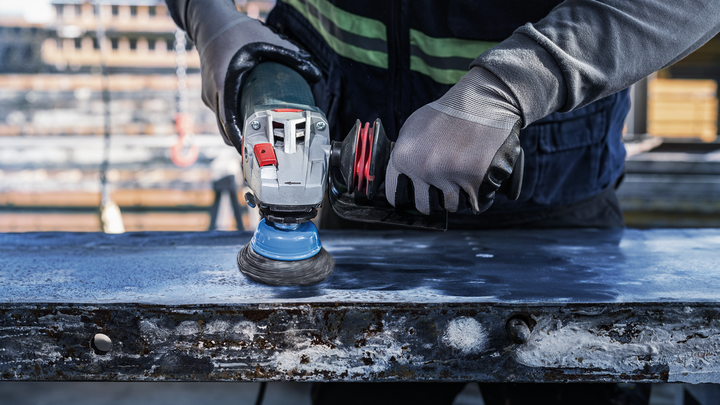Object #200476266: 3089952_app_web_3 Person wearing safety equipment grinds a metal surface with an angle grinder.