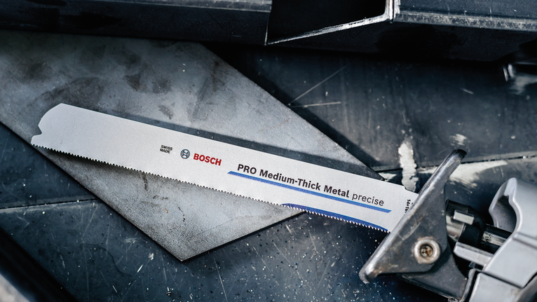 Saw blade mounted in a metal cutting tool on a workbench.