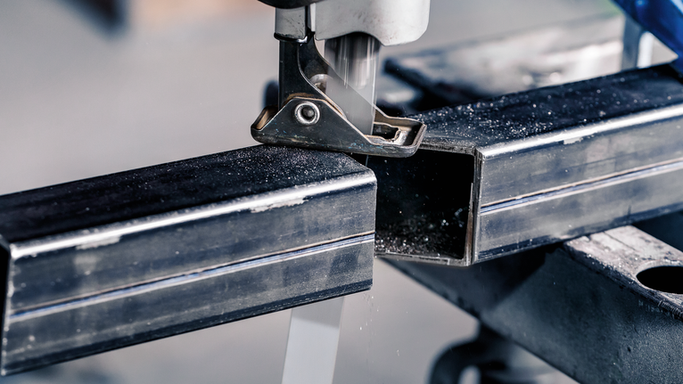 PRO Thick Metal precise S1237HBF Blade, 1.1 x 25 x 300 mm, 5 pcs Jigsaw cutting through a metal rectangular tube on a workbench.