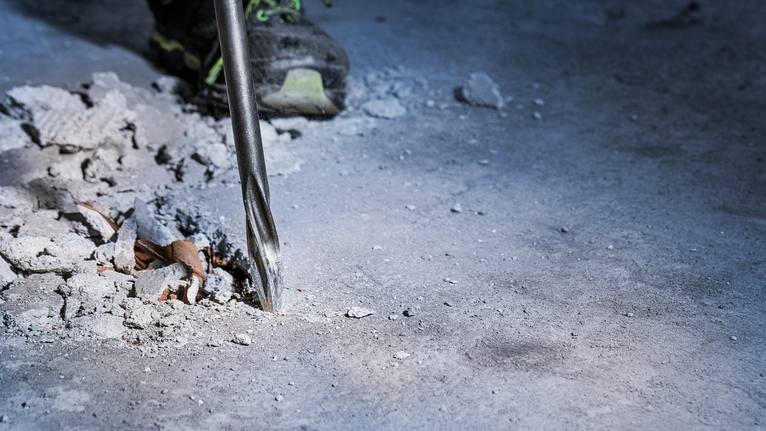 PRO SDS max-5C Flat Chisel, 25 x 400 mm Rotary hammer drill breaking through concrete floor.