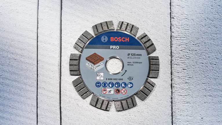 PRO Ceramic Diamond Disc, 105 x 20/16 mm Segmented diamond saw blade placed on a textured light concrete surface.