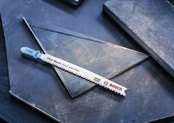 PRO Metal thick and thin T123XF Jigsaw Blade, 100 mm, 3 pcs Metal jigsaw blade resting on dark metal sheets.