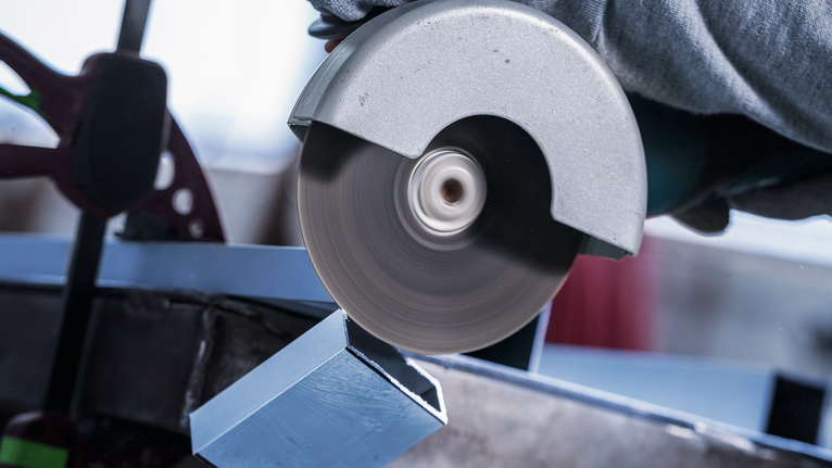 PRO Multi Material X-Lock Cutting Disc, 125 x 1 x 22.23 mm Worker wearing safety equipment uses a circular saw to cut a metal beam.