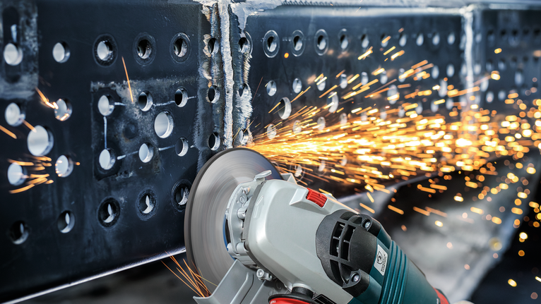 PRO Metal Grinding Disc, A 24 S BF, 180 x 6.6 x 22.23 mm, Depressed Centre Angle grinder cutting through a metal beam as sparks fly.