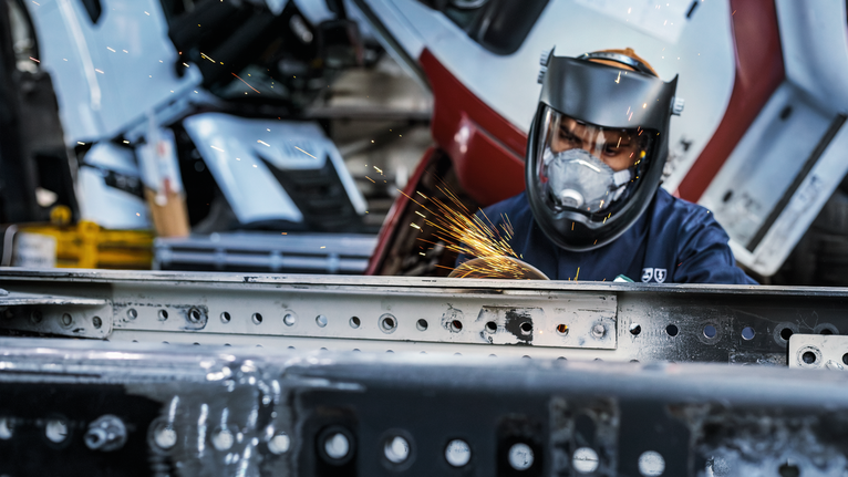 PRO Metal Grinding Disc, A 24 S BF, 180 x 6.6 x 22.23 mm, Depressed Centre Person wearing safety equipment grinds metal, creating bright sparks.