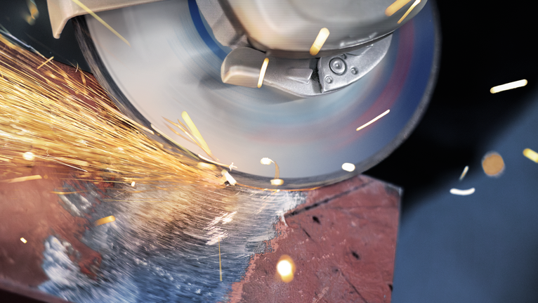 PRO Metal Grinding Disc, A 24 S BF, 180 x 6.6 x 22.23 mm, Depressed Centre Angle grinder cutting metal, producing bright sparks.