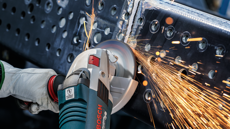 PRO Metal Grinding Disc, A 24 S BF, 180 x 6.6 x 22.23 mm, Depressed Centre Person wearing safety equipment grinds a metal beam, producing sparks.