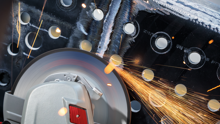 PRO Metal Grinding Disc, A 24 S BF, 180 x 6.6 x 22.23 mm, Depressed Centre Cutting tool grinding through perforated metal, sparks flying.