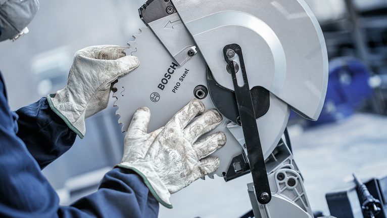 PRO Steel Circular Saw Blade, Corded, 254 x 2.2 x 25.4 mm, T52 Person wearing safety equipment adjusts a circular saw blade.
