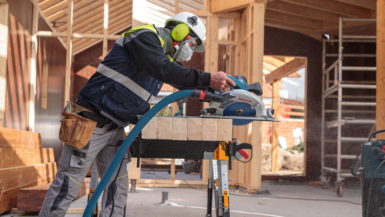 EXPERT Wood Circular Saw Blade, 165 x 2.6/1.6 x 20 mm, T24 Person wearing safety equipment cuts timber with a circular saw at a construction site.