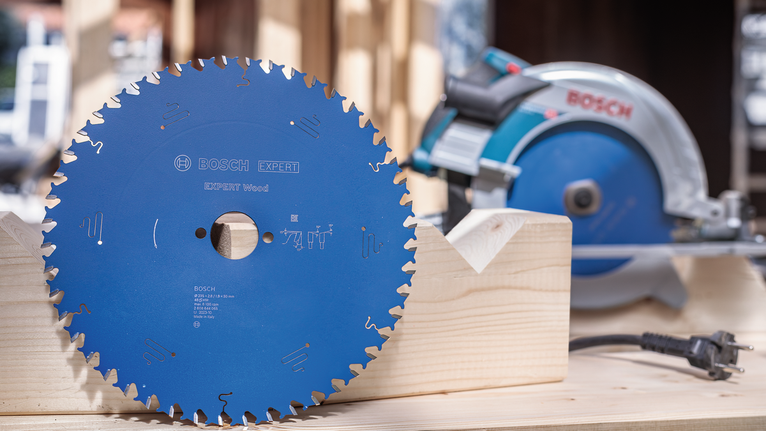 EXPERT Wood Circular Saw Blade, 165 x 2.6/1.6 x 20 mm, T24 Circular saw blade on a wooden workbench, power saw placed in the background.