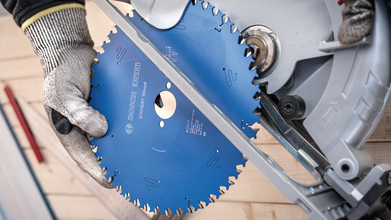 EXPERT Wood Circular Saw Blade, 165 x 2.6/1.6 x 20 mm, T24 Person wearing safety equipment installs a circular saw blade on a miter saw.