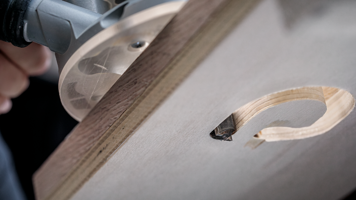 Object #200587672: 7437775_app_web_04 Wood router carving a precise circular hole in a wooden board.
