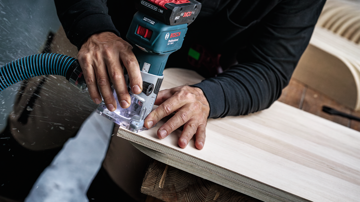 Object #200587675: 7437775_app_web_07 Person smooths edge of a wooden board using a cordless router.