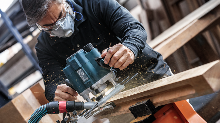 Object #200587729: 7437793_app_web_03 Person wearing safety equipment trims wood with a power router.
