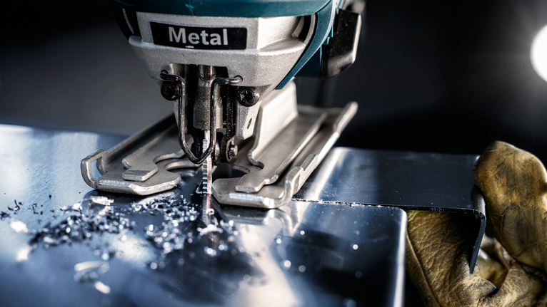 EXPERT Tough Metal medium T118EHM Jigsaw Blade, 3 pcs Person wearing safety equipment uses a jigsaw to cut a sheet of metal.