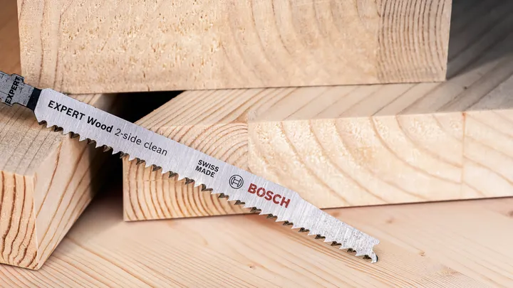 Saw blade resting on stacked cut timber pieces.