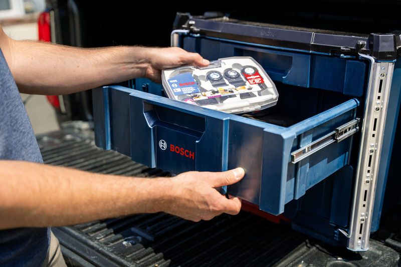 A person slides open a contractor drawer carrying case system to store a tool kit.