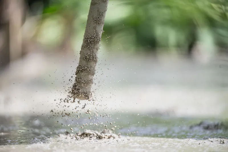 Concrete vibrator dispersing bubbles in freshly poured cement.